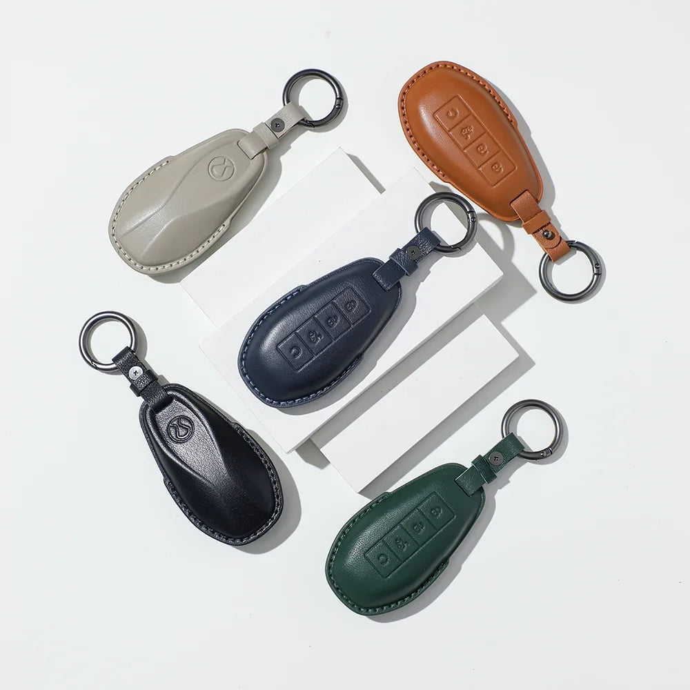 Set of five premium leather car key fob covers in tan, navy, black, dark green, and beige.