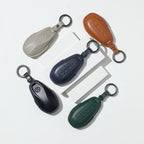 Set of five premium leather car key fob covers in tan, navy, black, dark green, and beige.