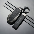 Black leather Denza car key case with matching branded strap and silver hardware.
