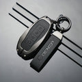 Black leather Denza car key case with matching branded strap and silver hardware.