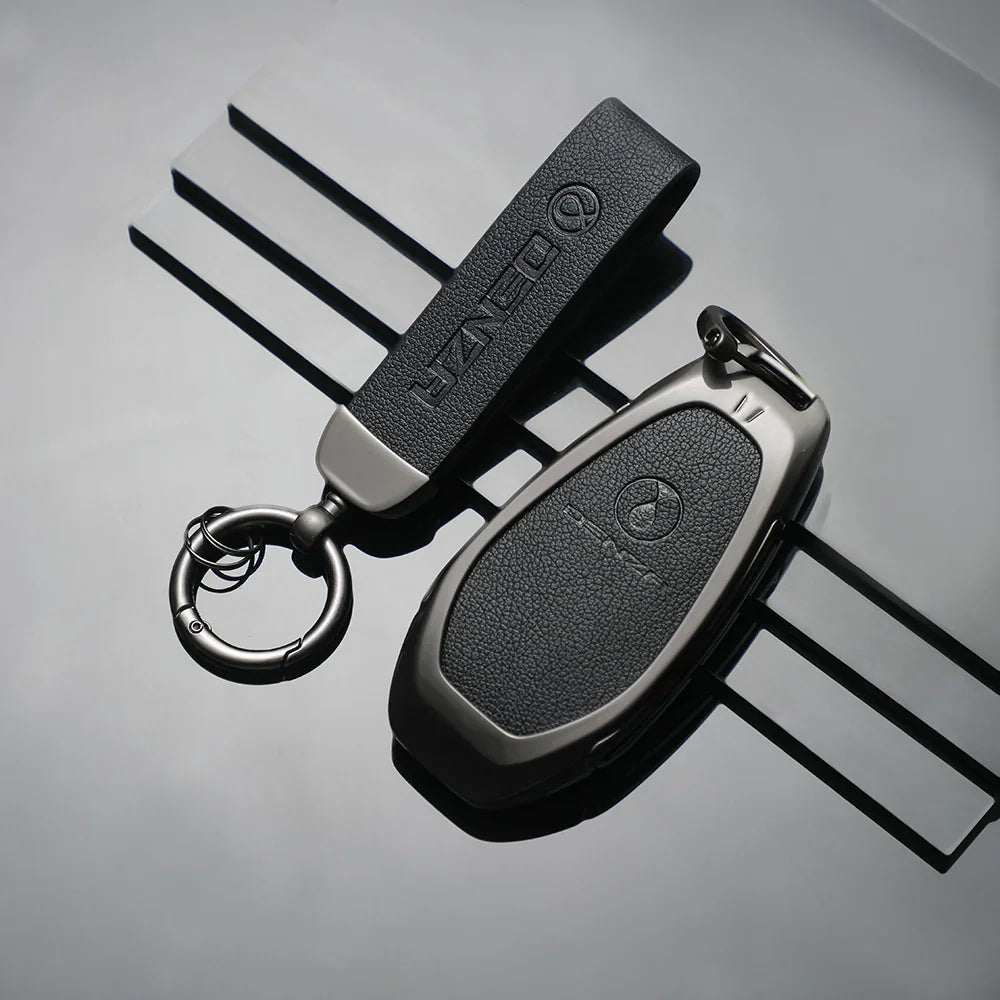Professional black leather car key cover and matching strap with textured finish.