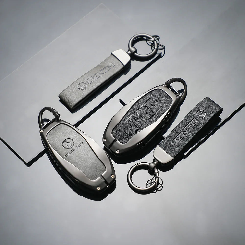 Three professional matte black metal DENZA car key covers with durable rings on a dark surface.
