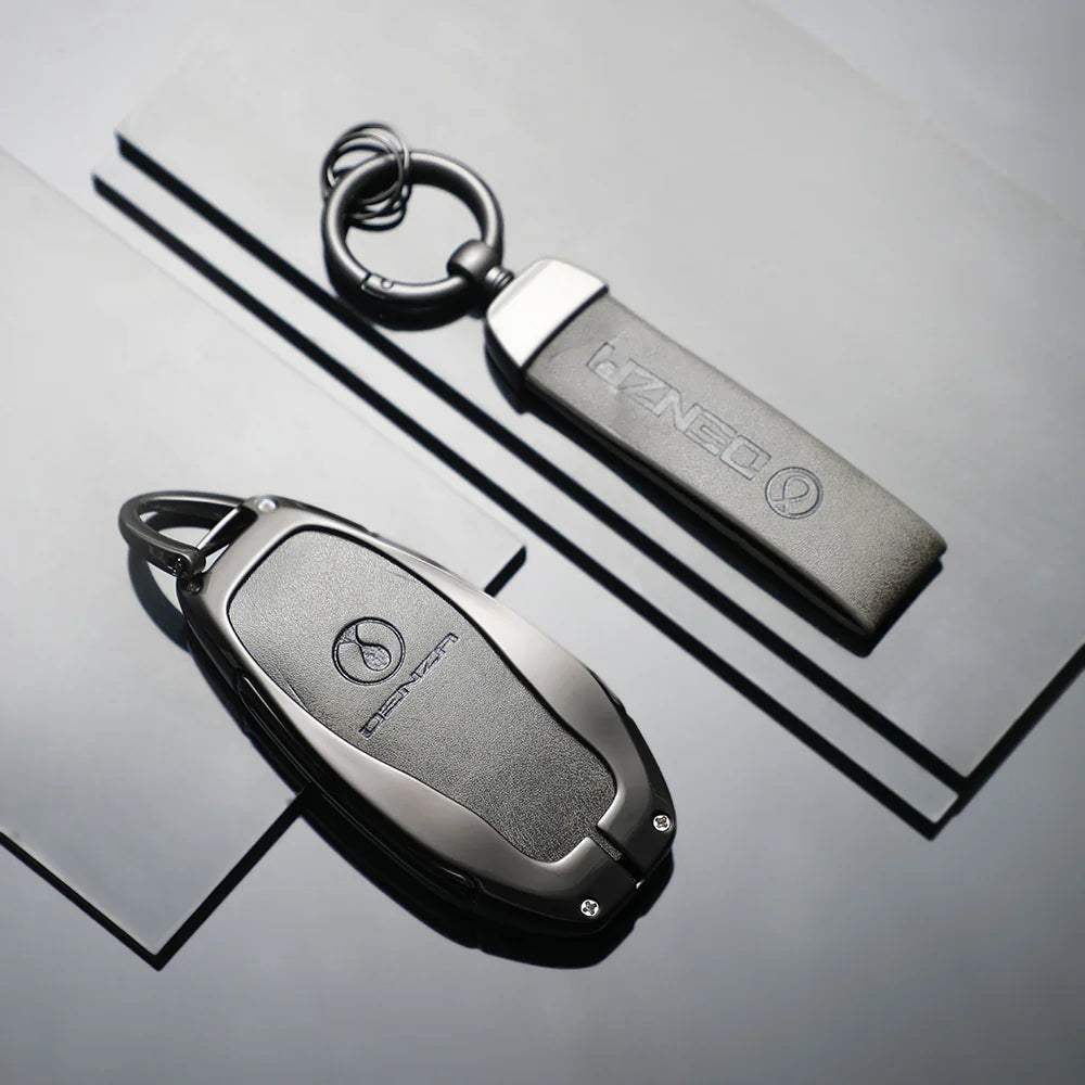 Premium matte black Denza car key fob and matching leather keychain accessory.