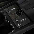 Close-up of a sleek black center console with a crystal-style gear shifter and tactile controls.