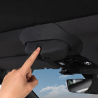 Black fabric-covered overhead console control button being pressed in a car interior.