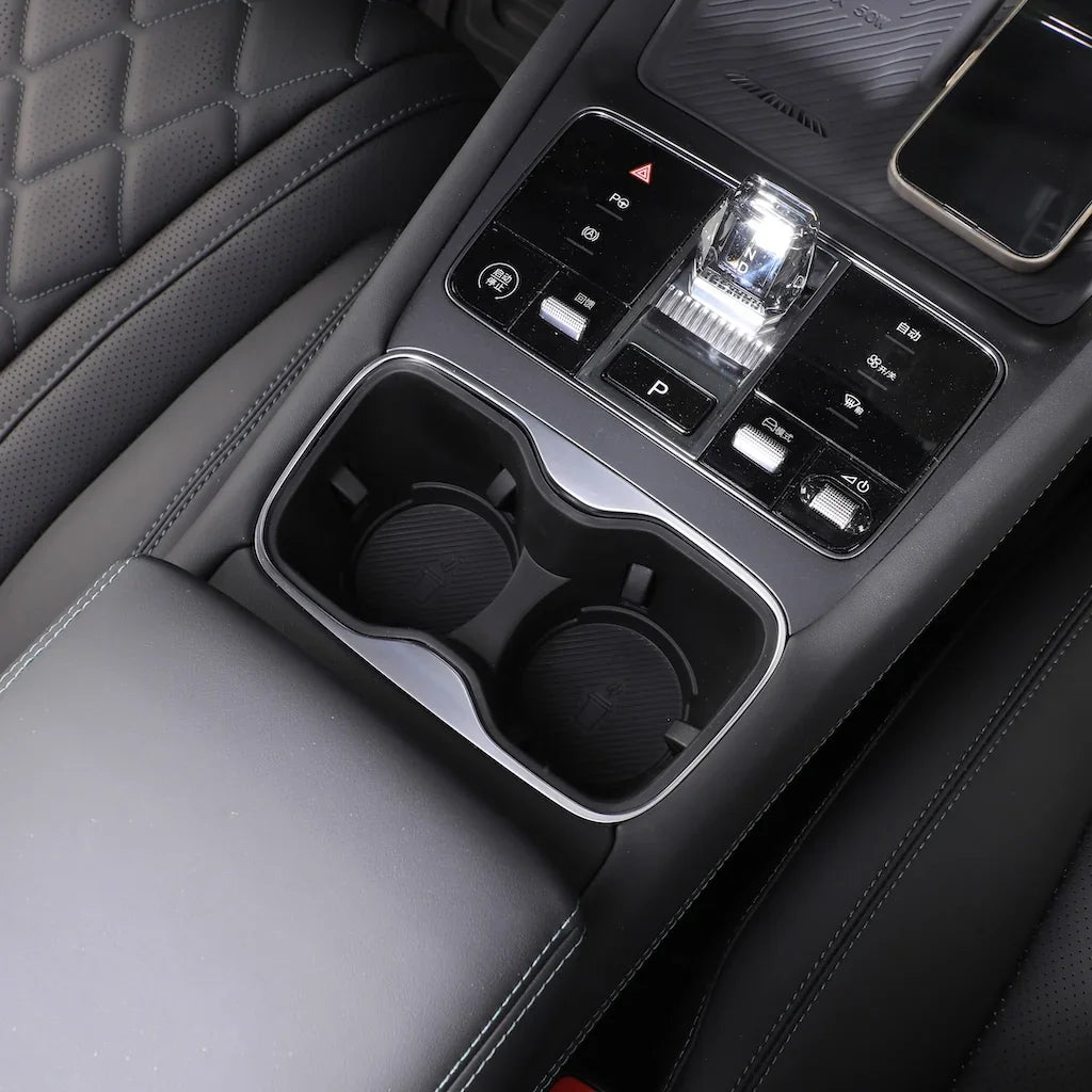 Black leather interior featuring dual cup holders and a sleek chrome gear shifter console.