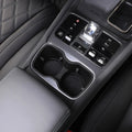 Black leather interior featuring dual cup holders and a sleek chrome gear shifter console.