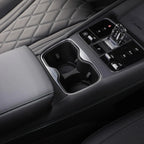 Black leather car interior featuring a dual cup holder and sleek center console controls.