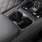 Black leather car interior featuring a dual cup holder and sleek crystal gear shifter.