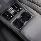 Black leather center console with chrome-trimmed dual cup holders and integrated control buttons.