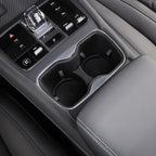 Black leather interior featuring a dual chrome-trimmed cup holder and electronic gear shifter.