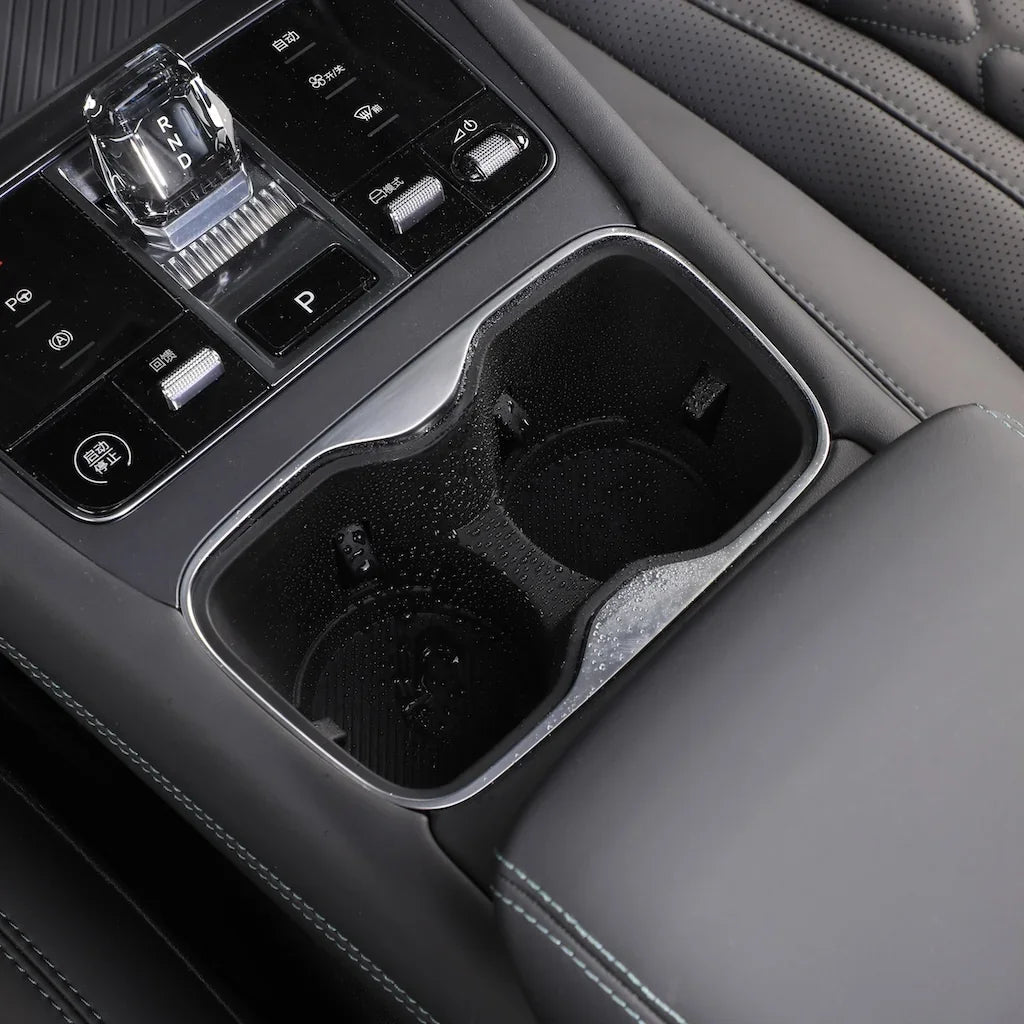 Black leather interior featuring a sleek chrome-trimmed dual cup holder for BYD accessories.