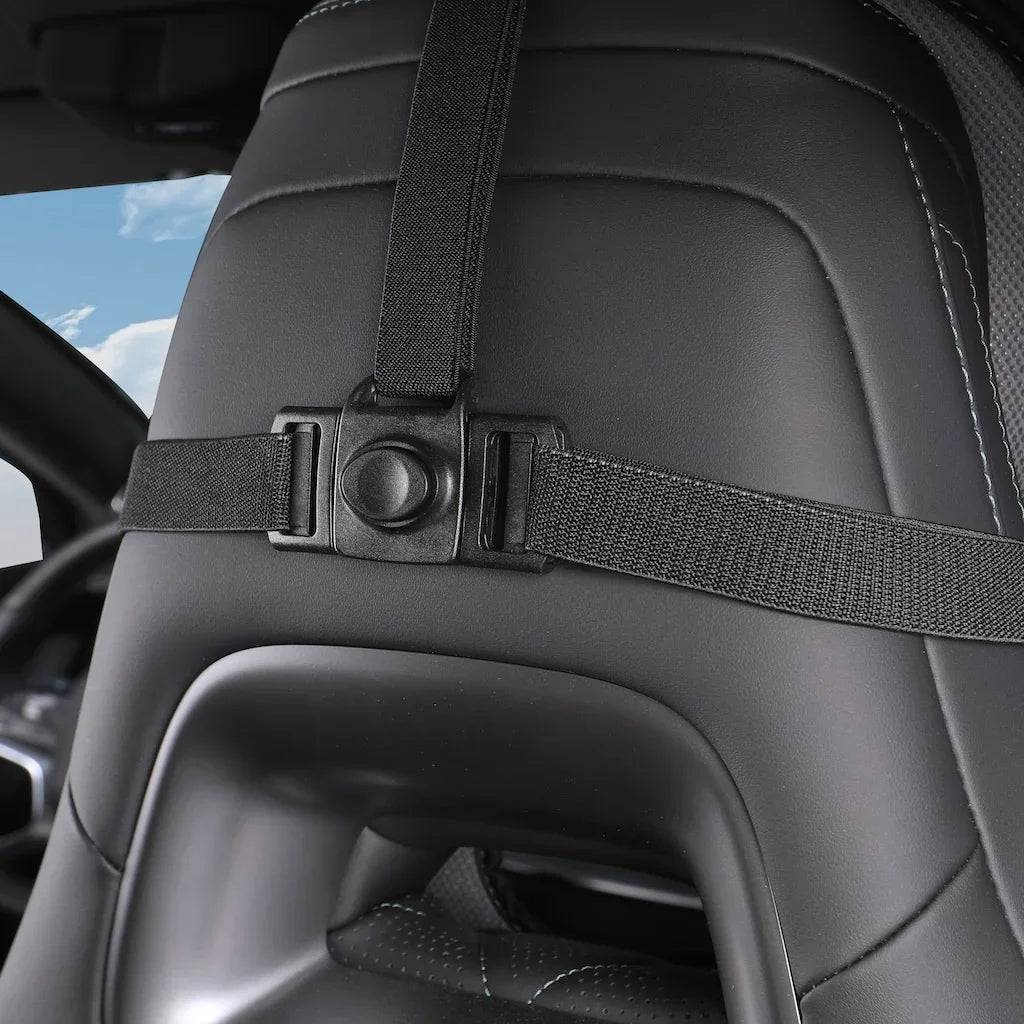 Close-up of a black heavy-duty nylon strap with a secure buckle on a leather car seat.