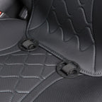 Close-up of black perforated leather car seat covers with quilted stitching and secure fasteners.
