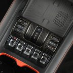Carbon fiber texture gear shifter panel with P R N D controls and silver metallic accents.