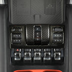 Carbon fiber texture center console trim with black gear shifter and control buttons.