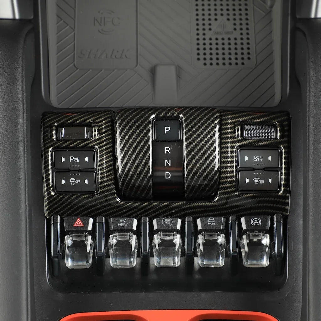 Carbon fiber texture center console trim with black gear shifter and control buttons.