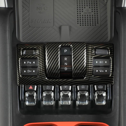 Carbon fiber texture center console trim with black gear shifter and control buttons.