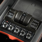 Carbon fiber texture center console control panel with black gear shifter and silver switches.