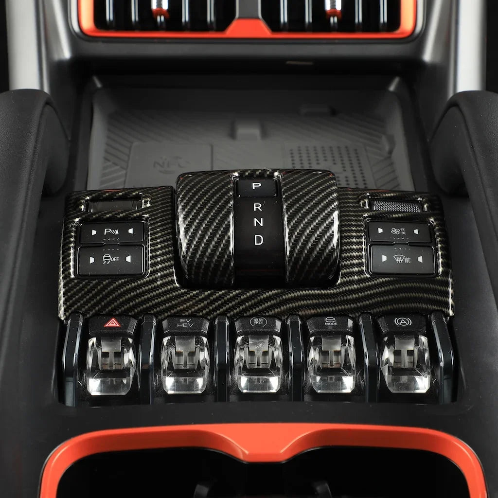 Carbon fiber texture gear shifter panel with black and red interior accents.