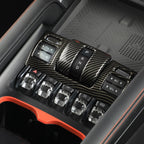 Carbon fiber texture center console trim with black gear shifter and crystal rocker switches.