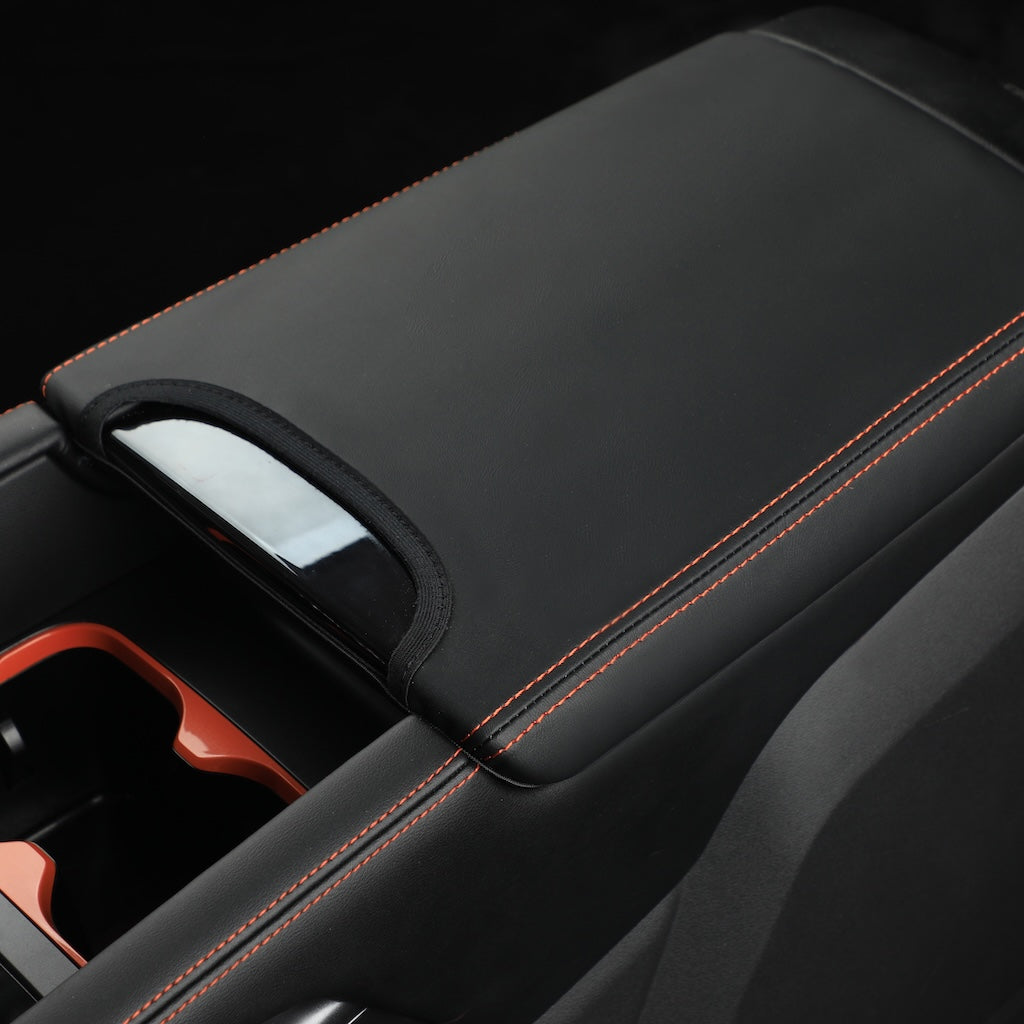 Black leather center console armrest cover with contrast orange stitching for BYD accessories.