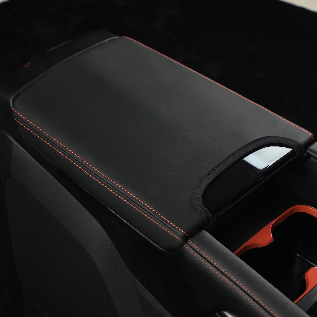 Black leather center console armrest cover with premium red contrast stitching.
