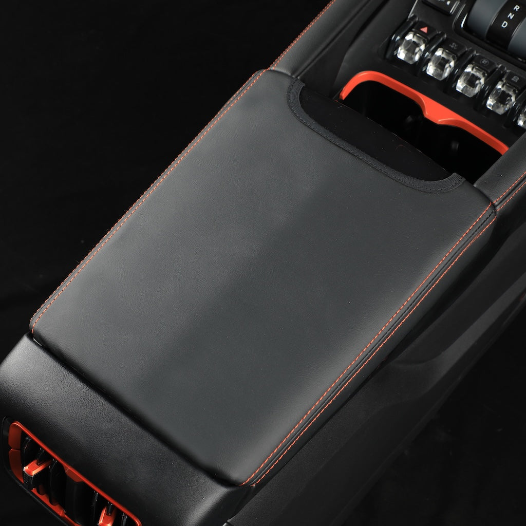 Black leather center console cover with orange contrast stitching for BYD vehicles.