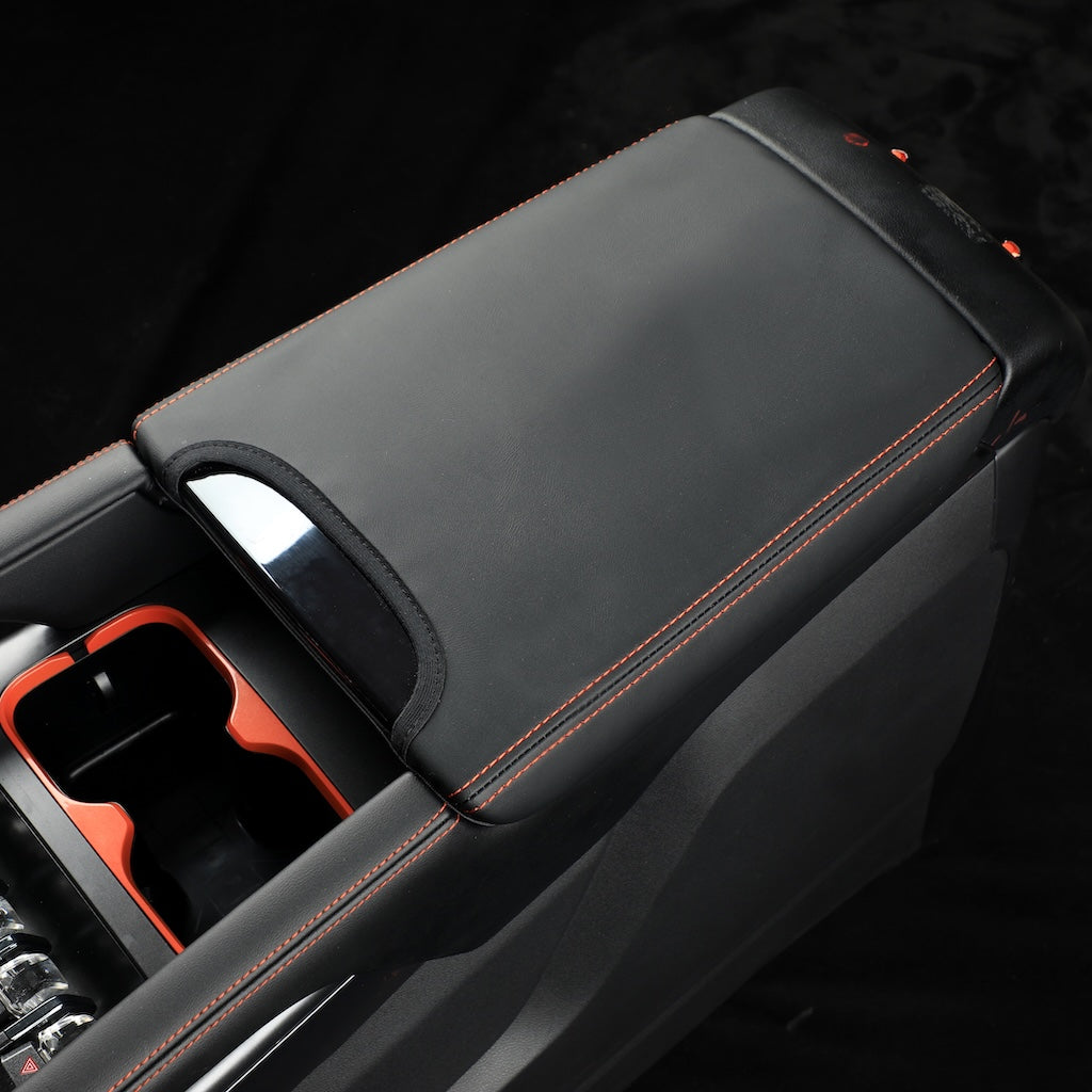 Black leather center console cover with orange contrast stitching for BYD car protection.