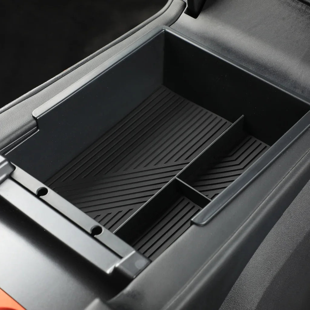 Black textured plastic center console organizer tray with divider for car interior.
