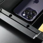 Close-up of a matte black durable plastic car organizer tray holding a purple smartphone.