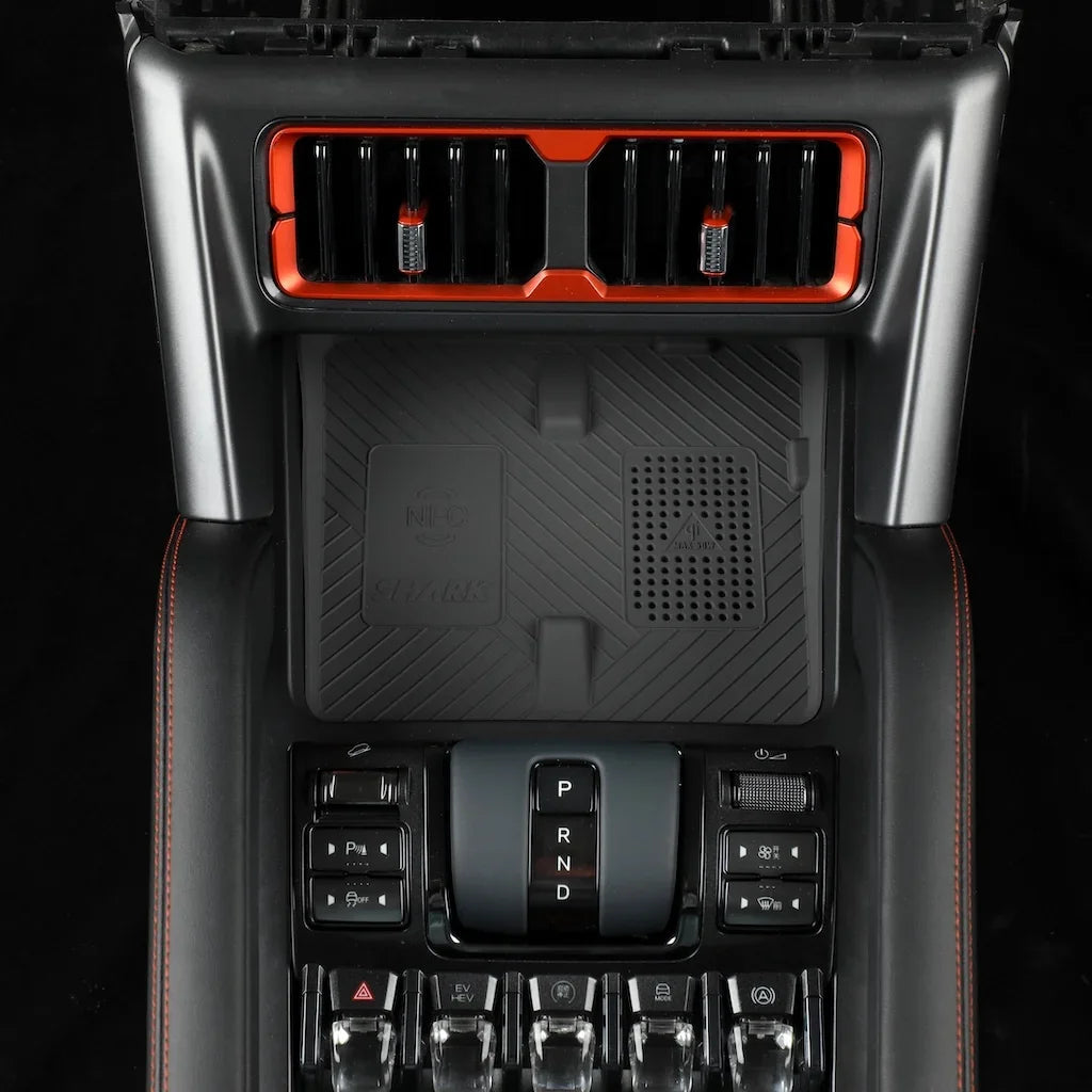 BYD car center console accessory with red accents and black textured NFC charging pad.