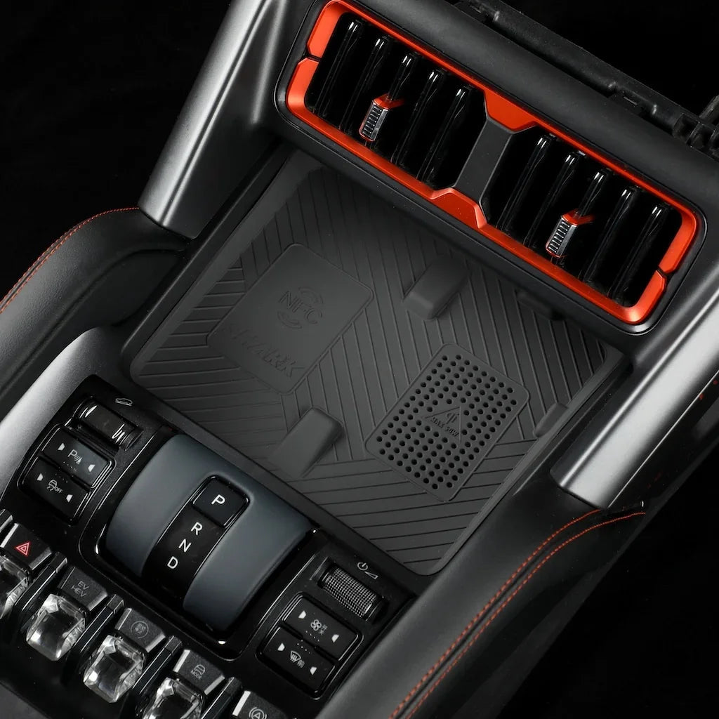 Matte black textured center console protector for BYD with orange trim accents.
