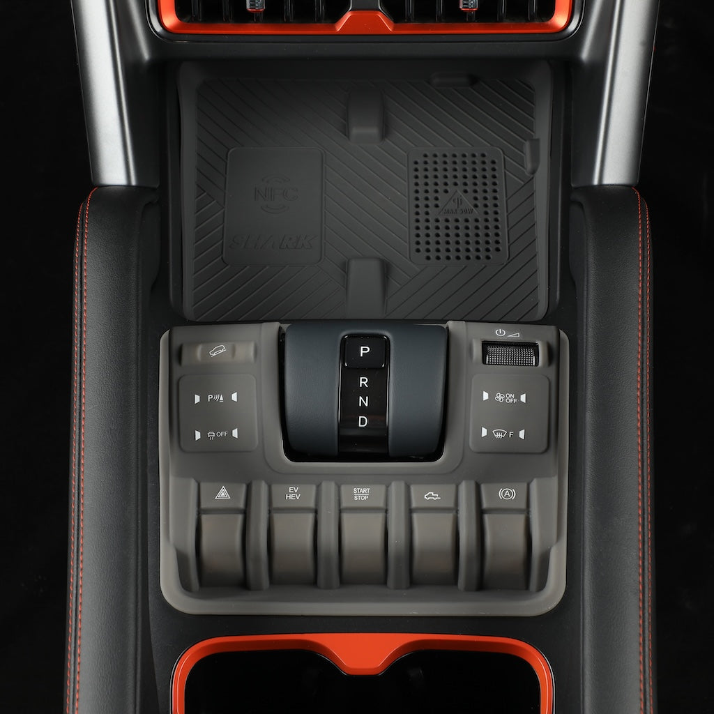 Close-up of a black center console with gear shifter and buttons in a modern vehicle interior.