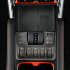 Close-up of a black center console with gear shifter and buttons in a modern vehicle interior.