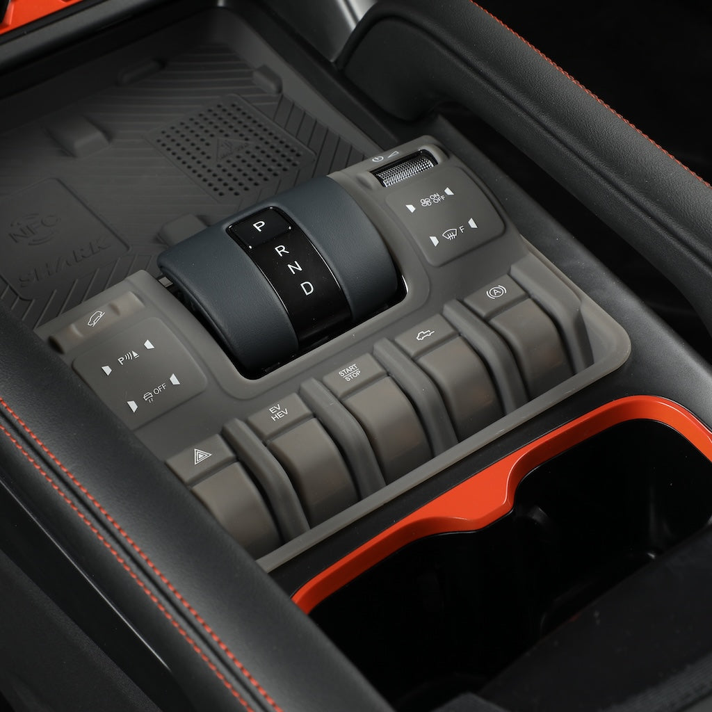 Black matte gear shifter with silver P R N D markings and gray control buttons in a car interior.