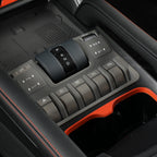 Black matte gear shifter with silver P R N D markings and gray control buttons in a car interior.