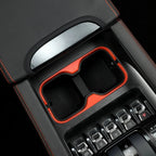 Black leather center console with vibrant red trim and dual storage compartments.