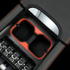 Black leather center console organizer with vibrant orange trim and dual storage compartments.
