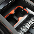 Black car center console cup holder with vibrant orange trim and durable non-slip mat.