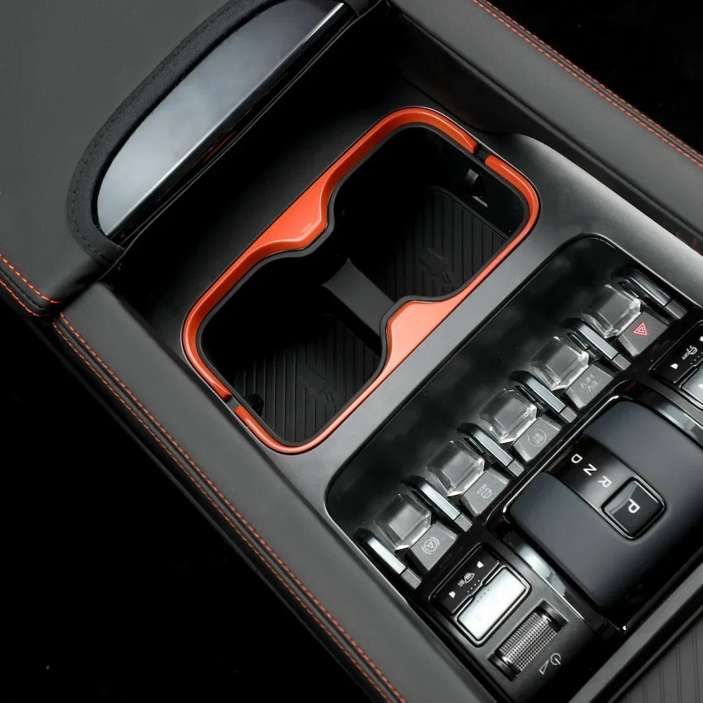 Black leather center console with orange trim and dual cup holders for BYD accessories.