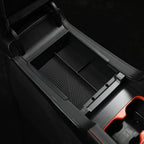 Close-up of a professional black plastic car center console organizer with a textured interior.