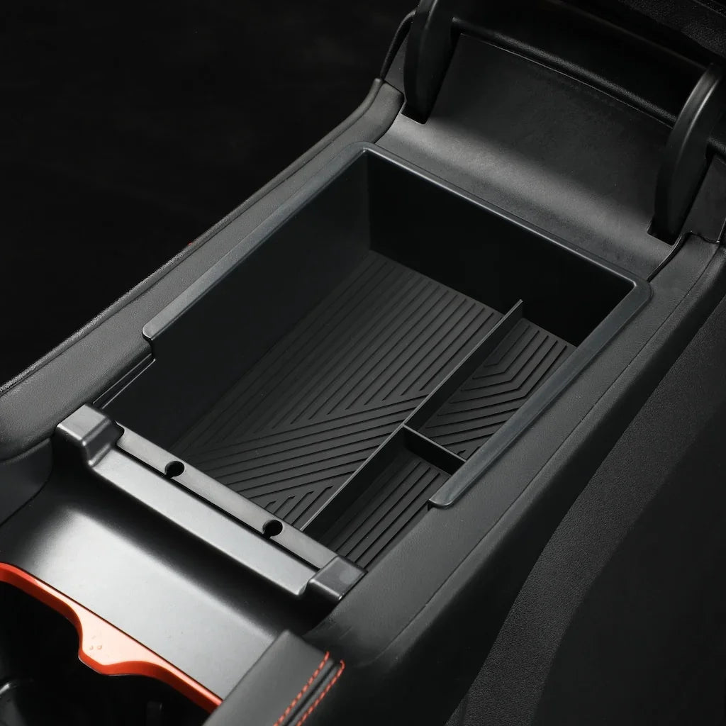 Black matte plastic center console organizer tray with anti-slip ribbed texture for car interiors