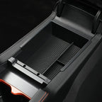 Black matte plastic center console organizer tray with anti-slip ribbed texture for car interiors