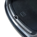 Close-up of a durable black plastic trunk sill protector installed on a grey vehicle.