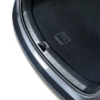 Close-up of a durable black plastic trunk sill protector installed on a grey vehicle.