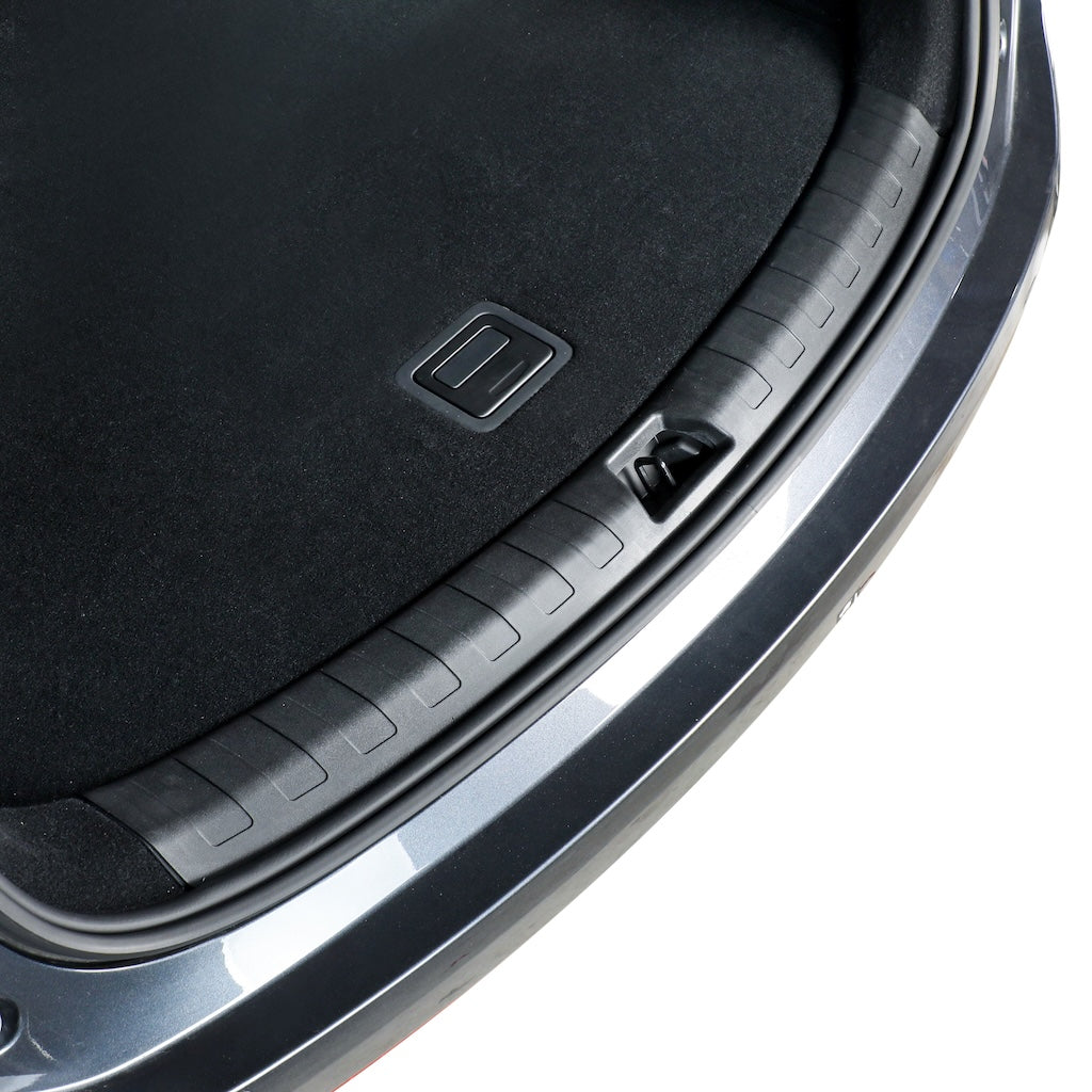 Close-up of a black textured car trunk liner with a protective ribbed edge.