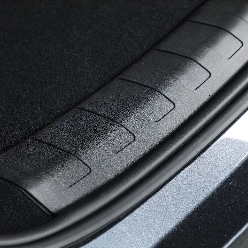 Close-up of a durable black textured plastic car trunk sill protector.