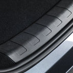 Close-up of a durable black textured plastic car trunk sill protector.