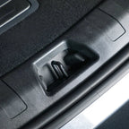 Close-up of a black durable plastic car interior component featuring a metal release lever.